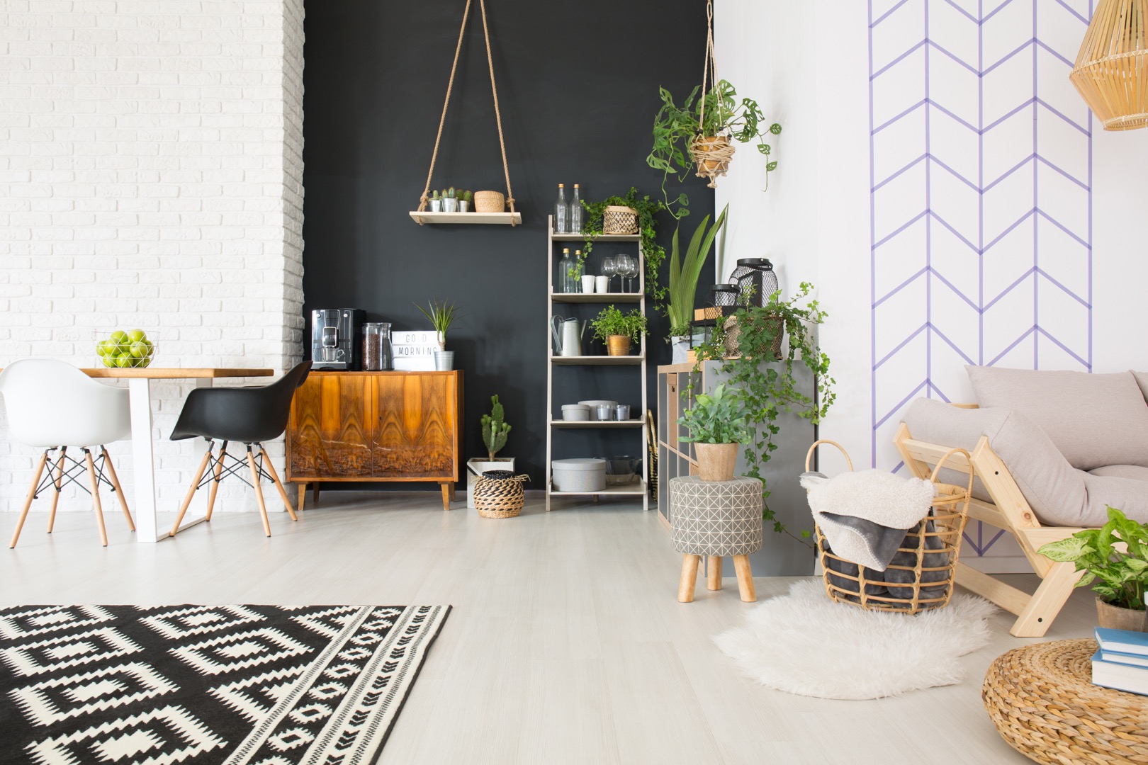 Modern black and white loft with commode, table, chair, plants